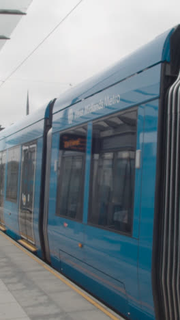 Vertical-Video-Of-Tram-Leaving-Station-Stop-Platform-In-Birmingham-UK